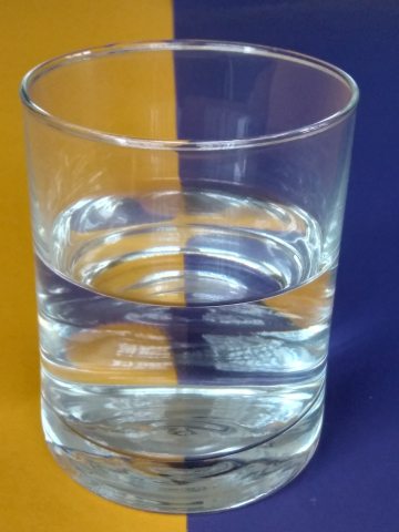 Das Foto zeigt ein Glas, das halbvoll gefüllt ist.